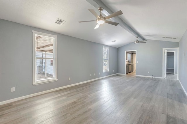 empty room with vaulted ceiling with beams, ceiling fan, and light hardwood / wood-style flooring