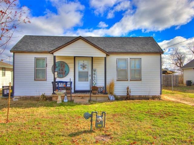 bungalow-style house with central air condition unit and a front yard