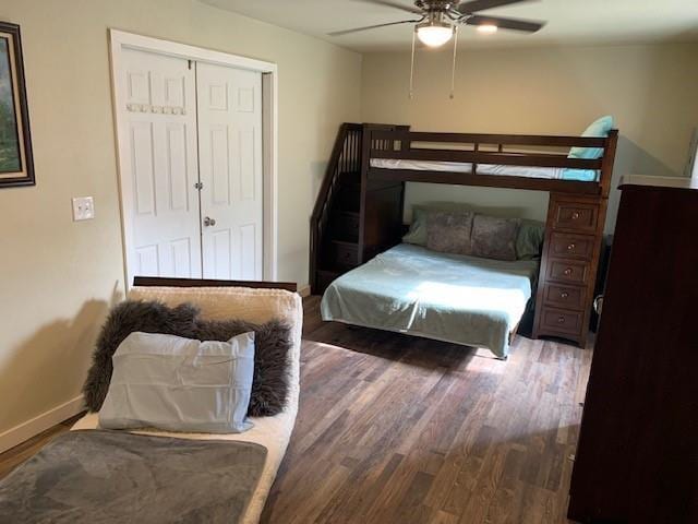 bedroom with ceiling fan, a closet, and dark wood-type flooring