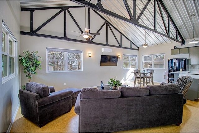 living room featuring ceiling fan, high vaulted ceiling, and light hardwood / wood-style floors