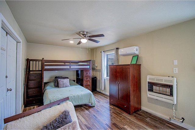 bedroom with heating unit, dark hardwood / wood-style floors, an AC wall unit, and ceiling fan