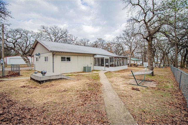 rear view of house with a sunroom and cooling unit