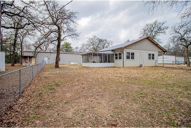 back of house with a lawn and a sunroom