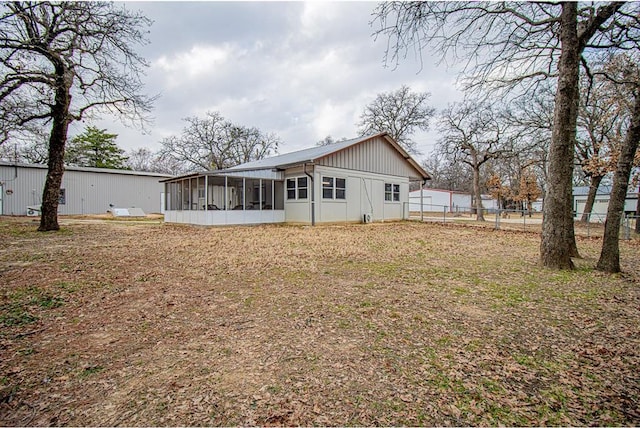 back of house with a yard and a sunroom