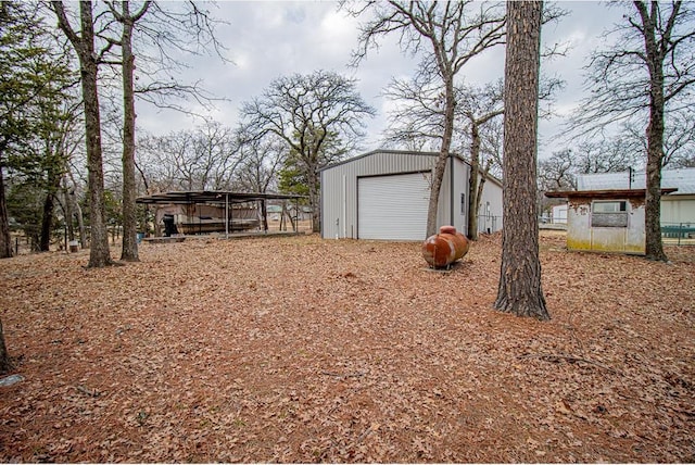 view of yard featuring a garage and an outbuilding