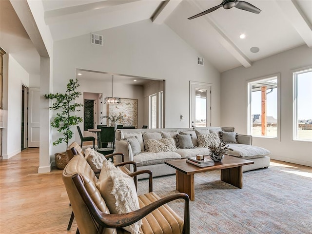 living room with ceiling fan, beam ceiling, light hardwood / wood-style floors, and high vaulted ceiling