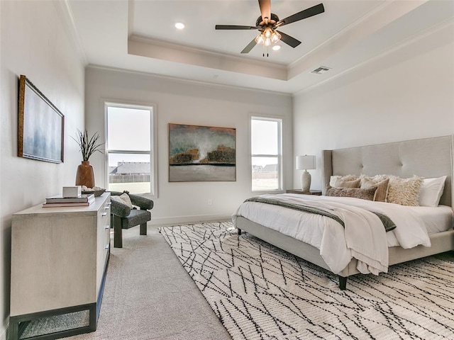 carpeted bedroom featuring a raised ceiling, ceiling fan, and ornamental molding