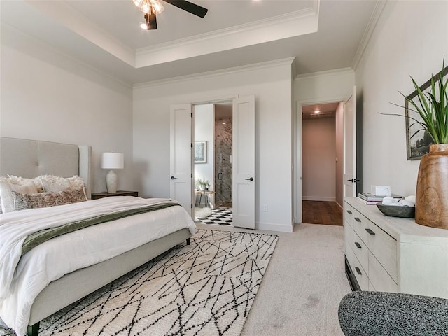 bedroom with light colored carpet, crown molding, ceiling fan, and a tray ceiling