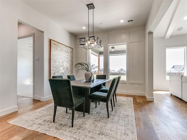 dining area with beam ceiling, ceiling fan, and light hardwood / wood-style floors