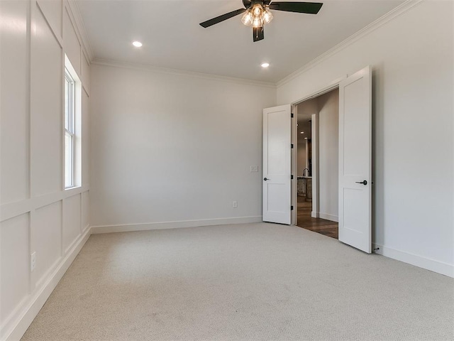 empty room featuring ceiling fan, carpet floors, and ornamental molding