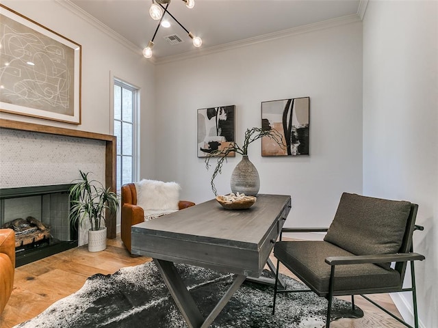 office with a tiled fireplace, crown molding, and hardwood / wood-style floors