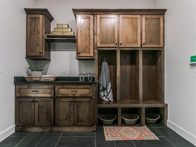 mudroom with dark tile patterned floors