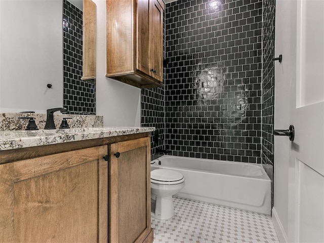 full bathroom featuring tile patterned flooring, toilet, vanity, and tiled shower / bath