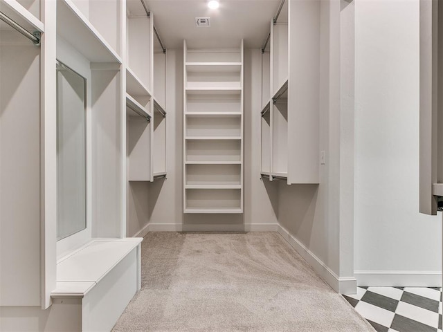 walk in closet featuring light colored carpet