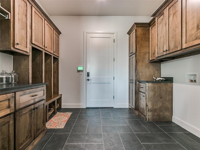 laundry room featuring cabinets, dark tile patterned floors, and hookup for a washing machine