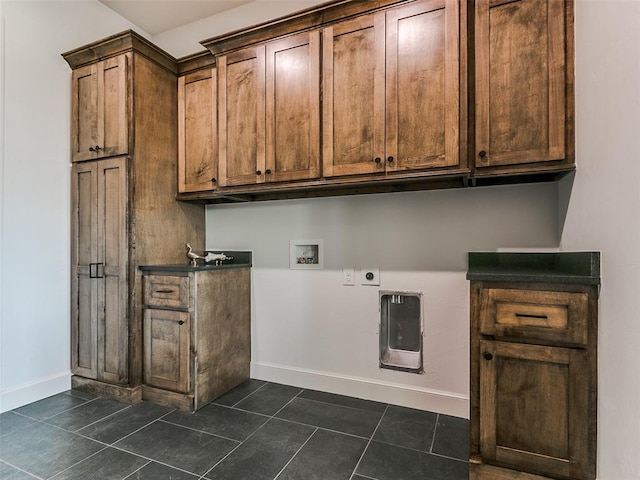 clothes washing area featuring cabinets, dark tile patterned floors, hookup for an electric dryer, and hookup for a washing machine