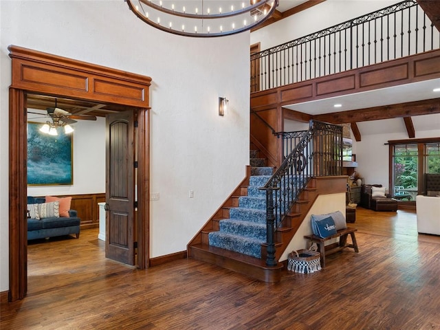 staircase with hardwood / wood-style floors, ceiling fan, beam ceiling, and high vaulted ceiling