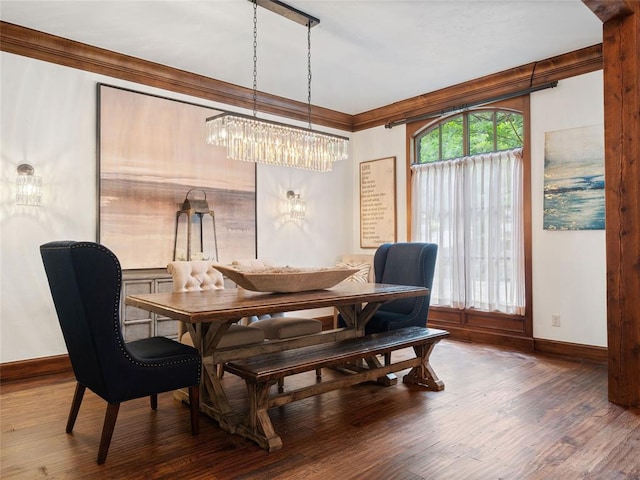 dining room with crown molding, dark hardwood / wood-style flooring, and a chandelier