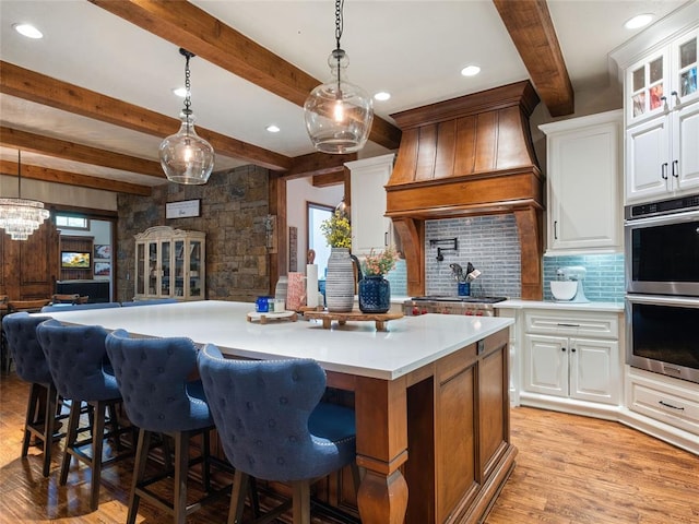 kitchen featuring beamed ceiling, appliances with stainless steel finishes, tasteful backsplash, and white cabinetry