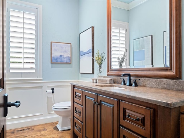 bathroom featuring crown molding, hardwood / wood-style floors, vanity, and a healthy amount of sunlight