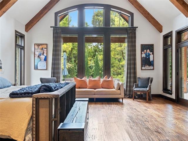 bedroom featuring beam ceiling, high vaulted ceiling, and wood-type flooring