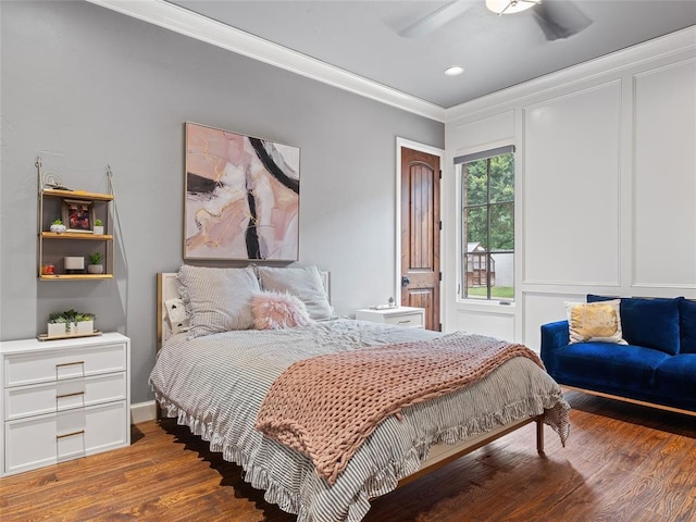 bedroom featuring dark hardwood / wood-style flooring, ceiling fan, and ornamental molding