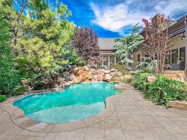 view of swimming pool featuring ceiling fan and a patio area