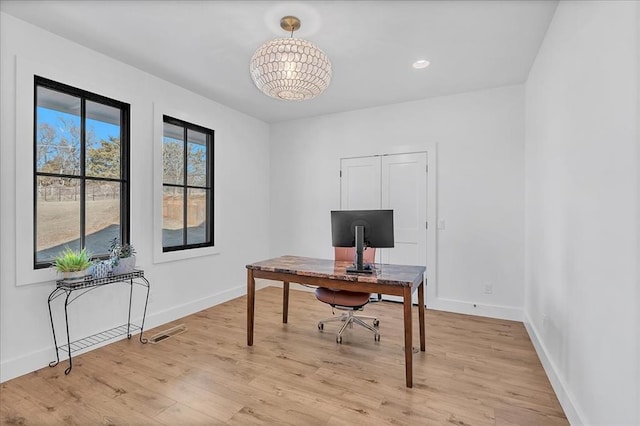 office featuring a notable chandelier and light hardwood / wood-style flooring