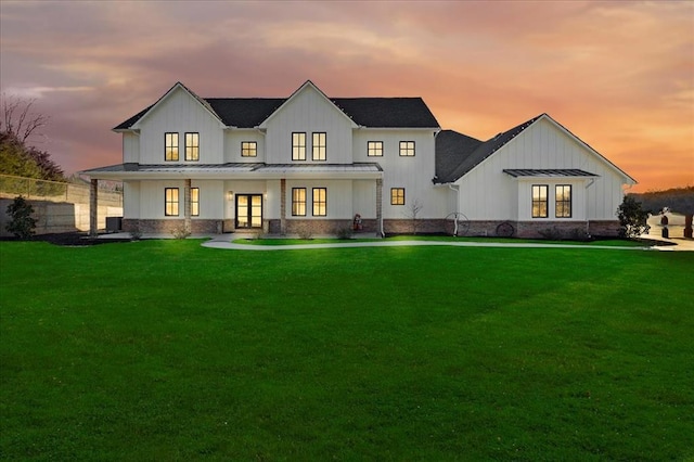 back house at dusk with a lawn