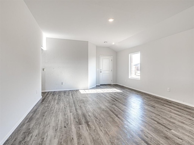 unfurnished room featuring dark hardwood / wood-style flooring and vaulted ceiling