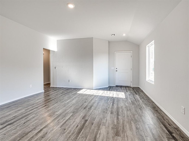 unfurnished room featuring vaulted ceiling and dark hardwood / wood-style flooring