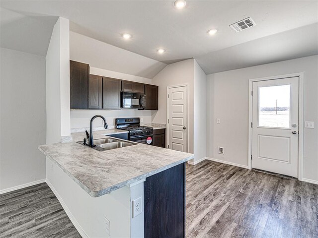 kitchen featuring sink, hardwood / wood-style flooring, dark brown cabinetry, black appliances, and vaulted ceiling