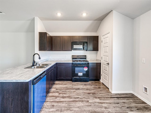 kitchen featuring sink, light hardwood / wood-style flooring, black appliances, vaulted ceiling, and kitchen peninsula