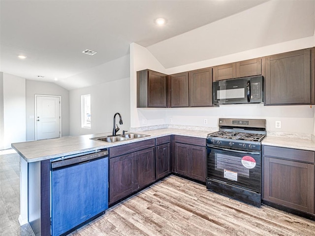 kitchen with sink, dark brown cabinets, black appliances, vaulted ceiling, and kitchen peninsula