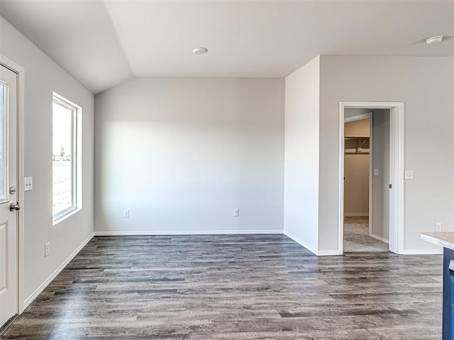 spare room with lofted ceiling, dark hardwood / wood-style floors, and a wealth of natural light