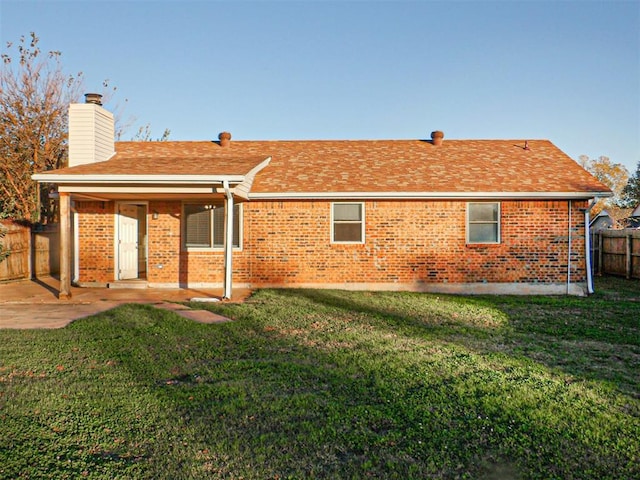 rear view of property featuring a lawn and a patio area