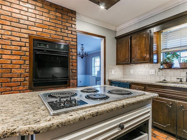 kitchen featuring dark brown cabinetry, crown molding, oven, decorative backsplash, and stainless steel cooktop