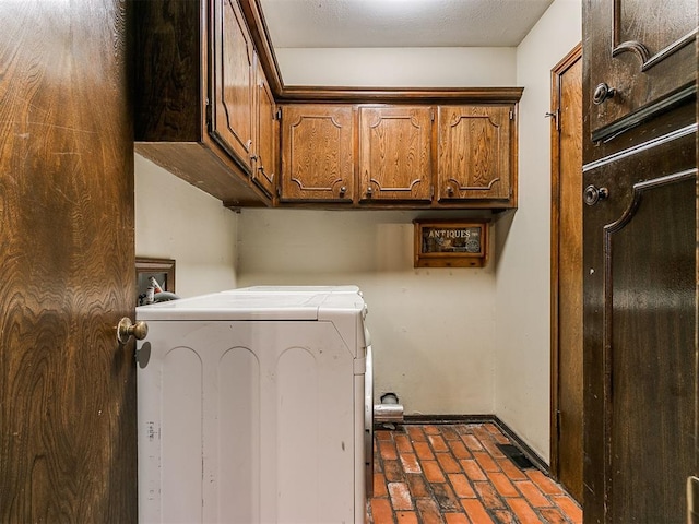 clothes washing area featuring cabinets and washer / clothes dryer