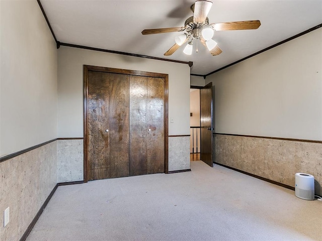 unfurnished bedroom featuring light carpet, ceiling fan, and ornamental molding