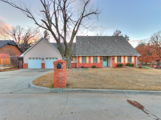 view of front of property with a garage and a lawn