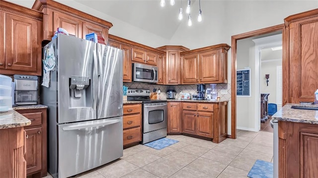 kitchen with sink, light stone countertops, light tile patterned floors, tasteful backsplash, and stainless steel appliances