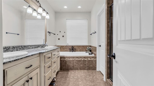 bathroom featuring tile patterned flooring, vanity, and plus walk in shower