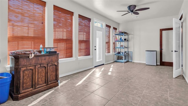 entryway featuring ceiling fan, light tile patterned flooring, and a healthy amount of sunlight