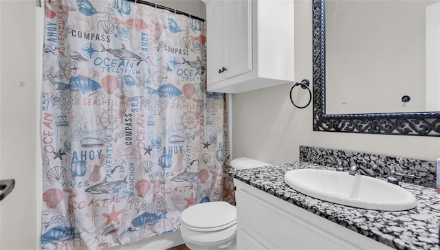 bathroom featuring curtained shower, vanity, and toilet