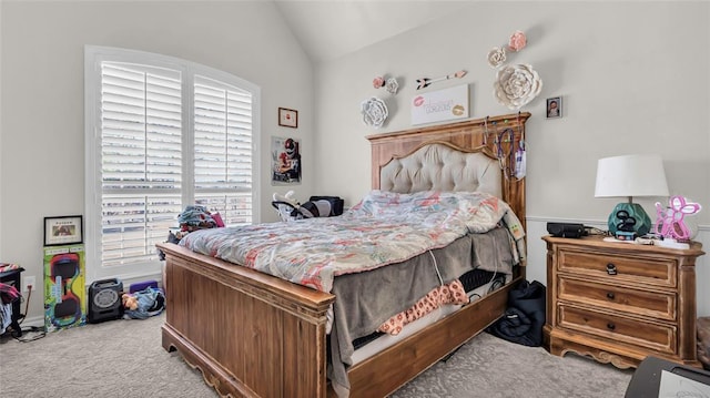 bedroom featuring light colored carpet and lofted ceiling