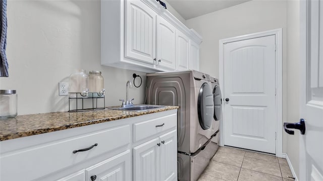 laundry area with cabinets, independent washer and dryer, sink, and light tile patterned floors