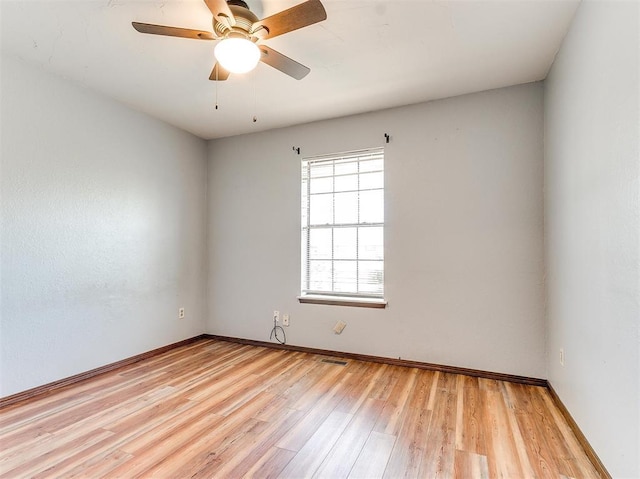 empty room with ceiling fan and light hardwood / wood-style flooring