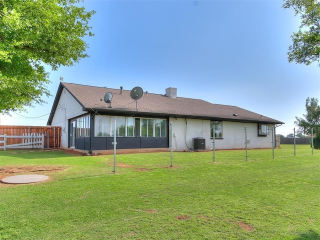 back of property featuring a sunroom, a yard, and cooling unit