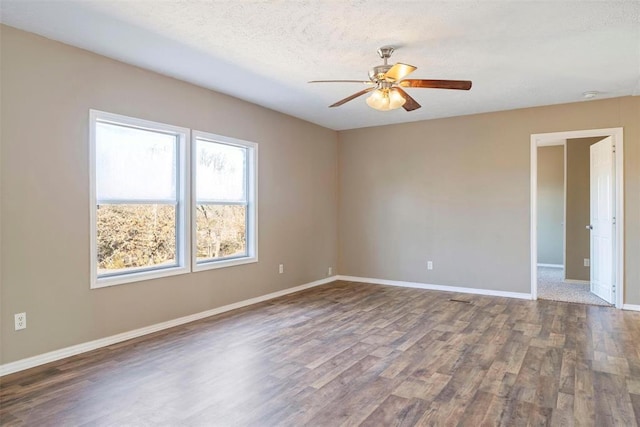 empty room with ceiling fan, dark hardwood / wood-style flooring, and a textured ceiling