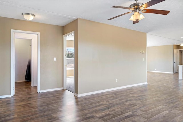 spare room with ceiling fan and dark wood-type flooring